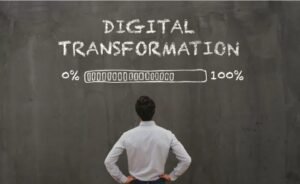 homem de costa lendo um qudro onde esta escrito em inglês transformaçao digital